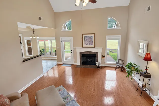 a view of a livingroom with furniture a fireplace and wooden floor