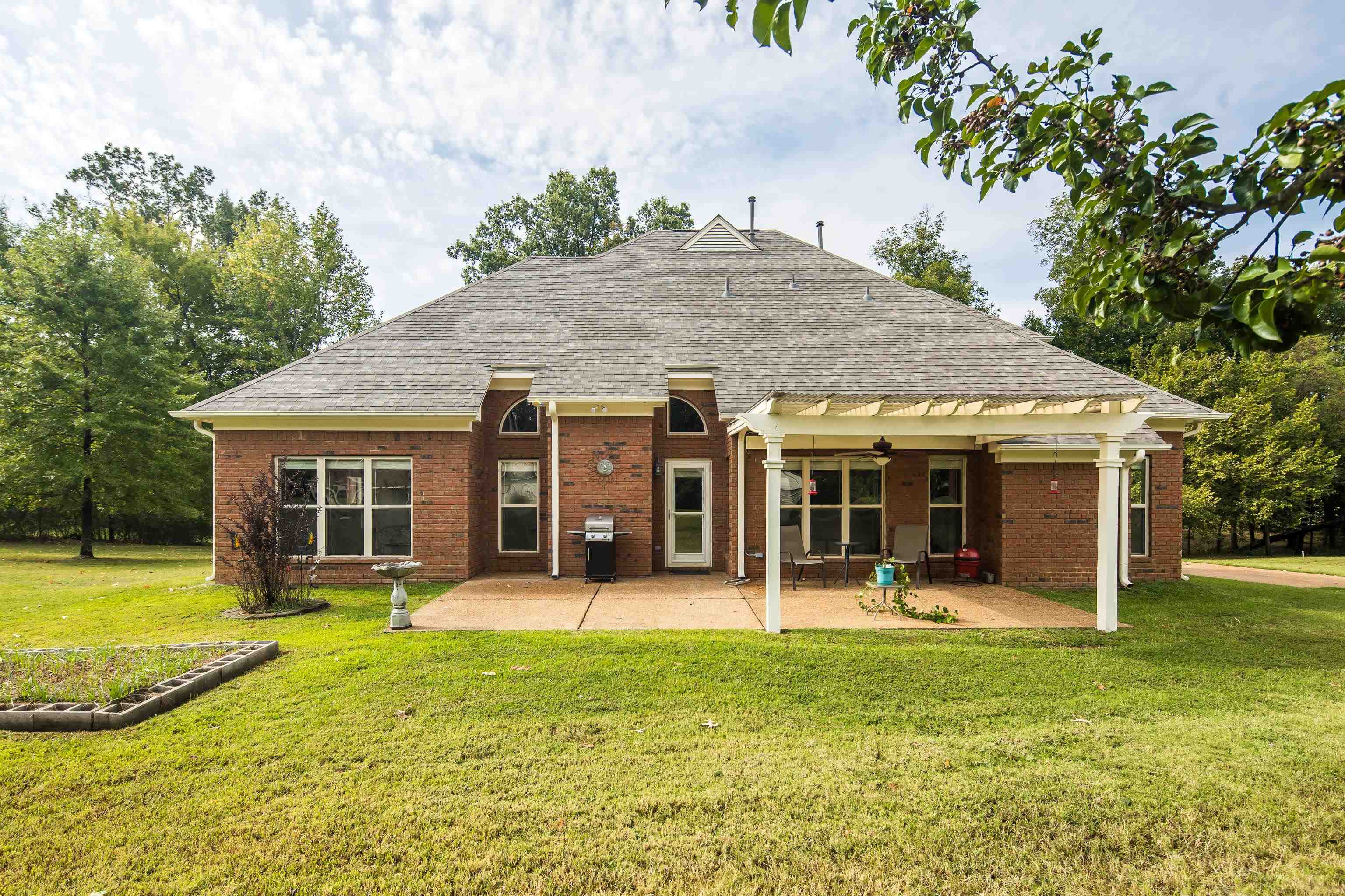 90 Rolling Meadows Road Somerville, TN 38068 - Photo 33 of 37 a view of a house with a yard potted plants and a large tree