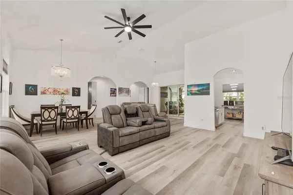 a view of a dining room with furniture a chandelier and wooden floor