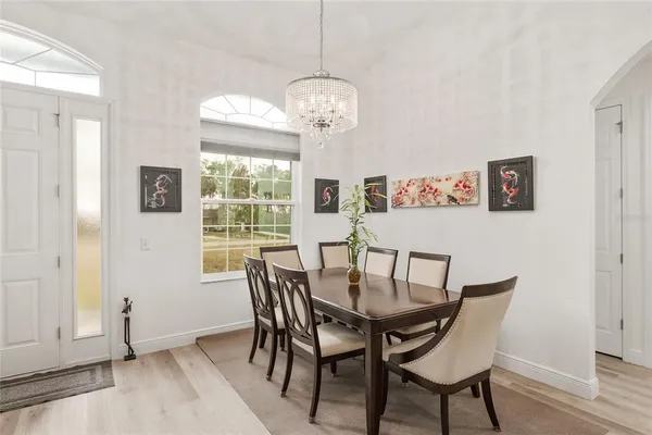 a living room with furniture kitchen view and a chandelier