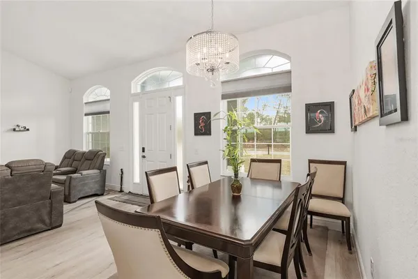 a living room with furniture kitchen view and a chandelier