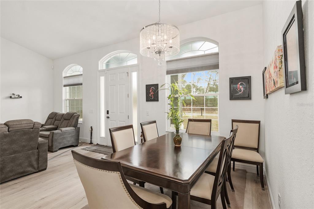 4321 Southwest 106th Place Ocala, FL 34476 - Photo 16 of 82 a view of a dining room with furniture a chandelier and wooden floor