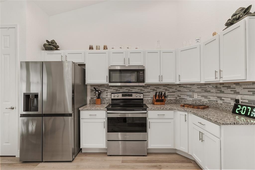 4321 Southwest 106th Place Ocala, FL 34476 - Photo 27 of 82 a kitchen with white cabinets and stainless steel appliances