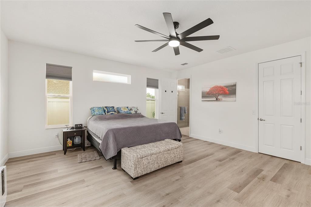 4321 Southwest 106th Place Ocala, FL 34476 - Photo 33 of 82 a spacious bedroom with a bed and a chandelier