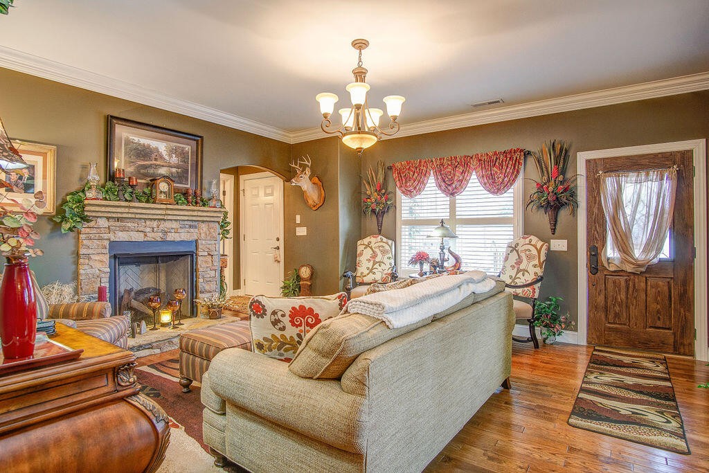 734 Bryant Road Cohutta, GA 30710 - Photo 13 of 42 a living room with fireplace furniture and a chandelier