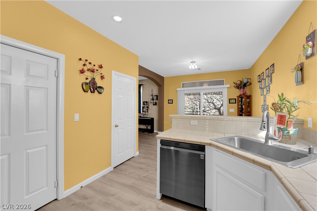 8170 West Festuca Way Las Vegas, NV 89113 - Photo 14 of 29 Kitchen with tile counters, arched walkways, stainless steel dishwasher, a peninsula, and recessed lighting