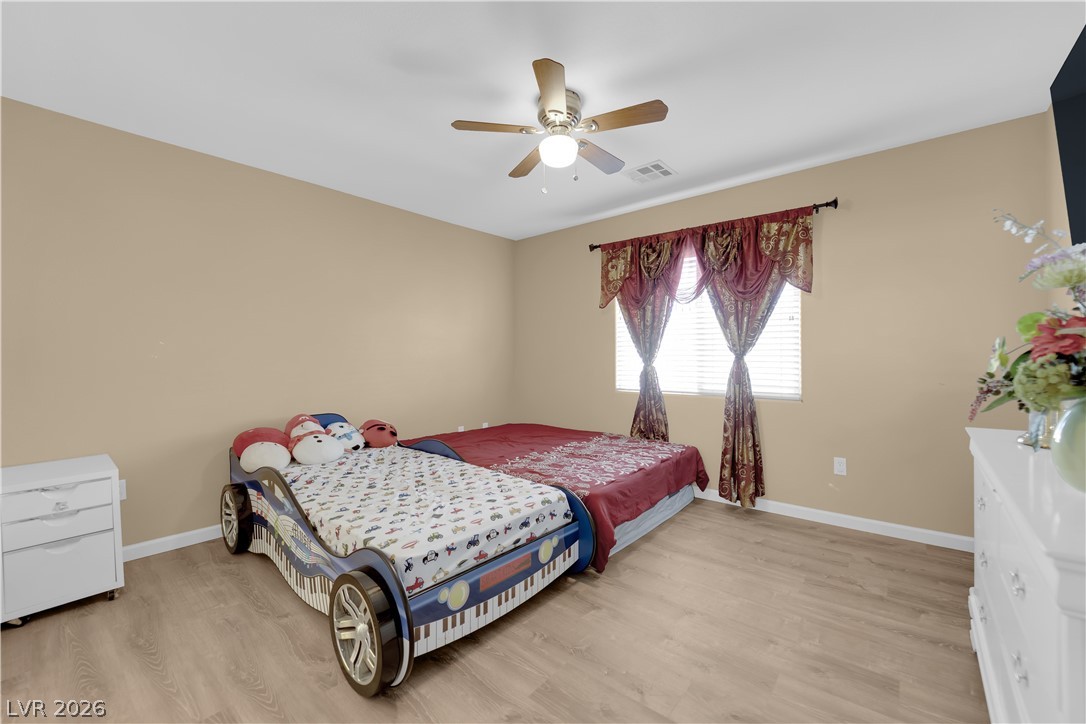 8170 West Festuca Way Las Vegas, NV 89113 - Photo 18 of 29 Bedroom featuring light wood-style floors and a ceiling fan