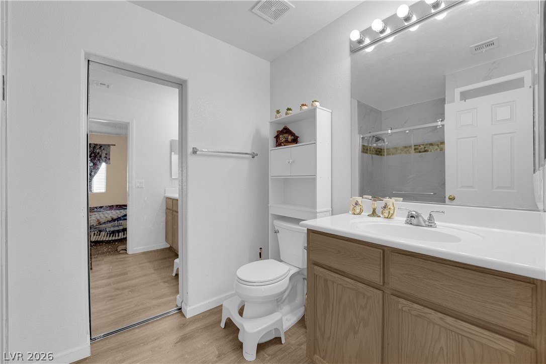 8170 West Festuca Way Las Vegas, NV 89113 - Photo 20 of 29 Full bathroom with vanity, a shower stall, and light wood-type flooring