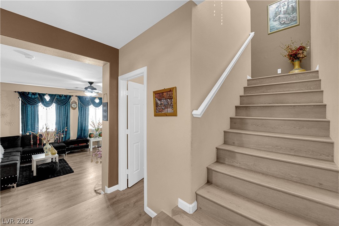 8170 West Festuca Way Las Vegas, NV 89113 - Photo 22 of 29 Staircase featuring a ceiling fan and wood finished floors
