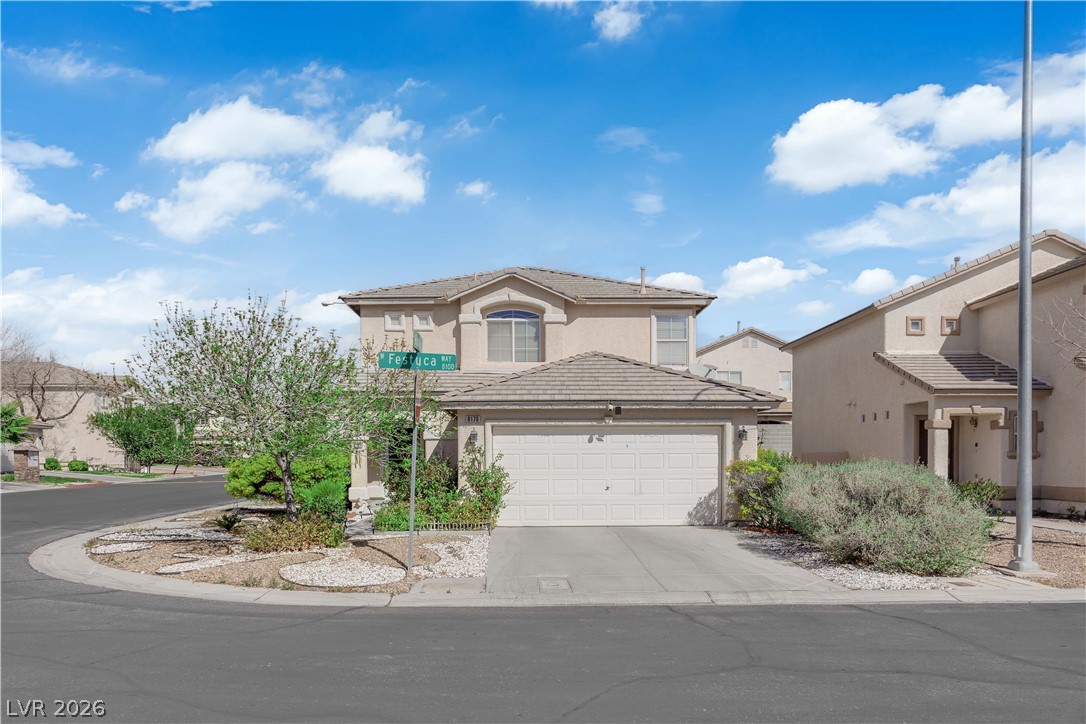 8170 West Festuca Way Las Vegas, NV 89113 - Photo 23 of 29 Traditional home with stucco siding, an attached garage, driveway, and a tile roof