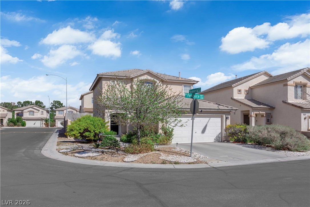 8170 West Festuca Way Las Vegas, NV 89113 - Photo 24 of 29 Traditional-style house with a residential view, stucco siding, an attached garage, and driveway