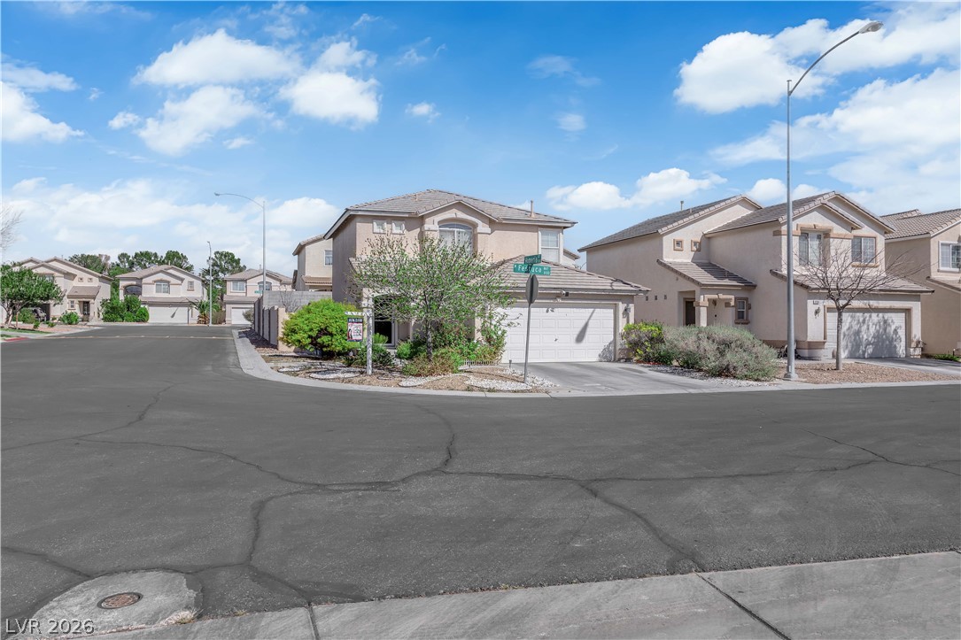 8170 West Festuca Way Las Vegas, NV 89113 - Photo 28 of 29 View of front of house with a residential view, stucco siding, a garage, and concrete driveway
