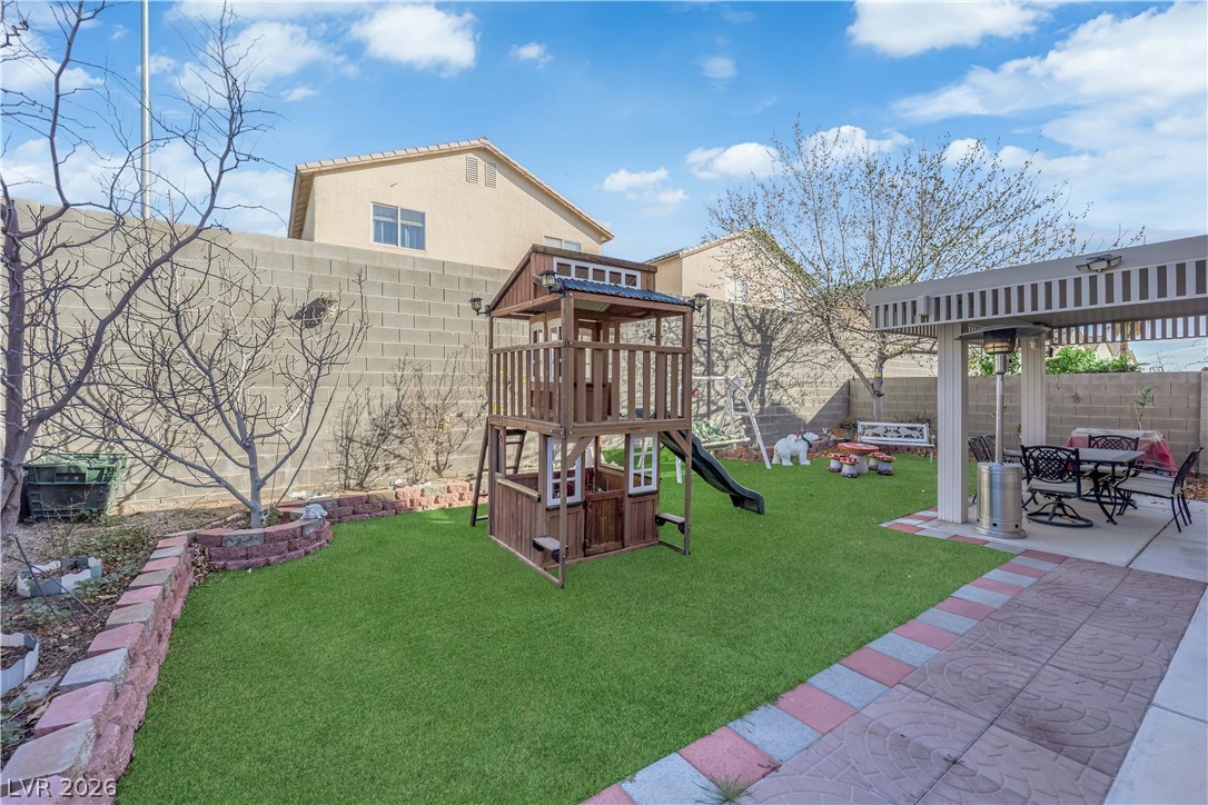 8170 West Festuca Way Las Vegas, NV 89113 - Photo 4 of 29 View of play area with a patio, a fenced backyard, a pergola, and outdoor dining area