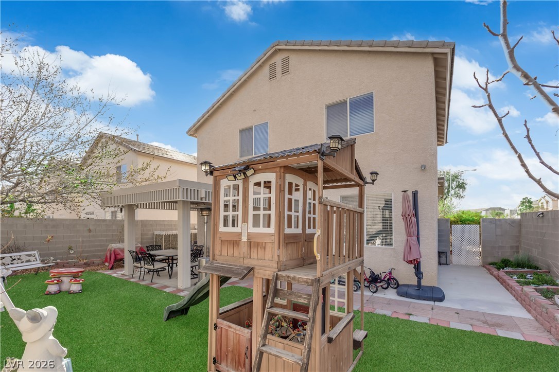 8170 West Festuca Way Las Vegas, NV 89113 - Photo 5 of 29 Back of property featuring a patio, a fenced backyard, stucco siding, a gate, and a gazebo