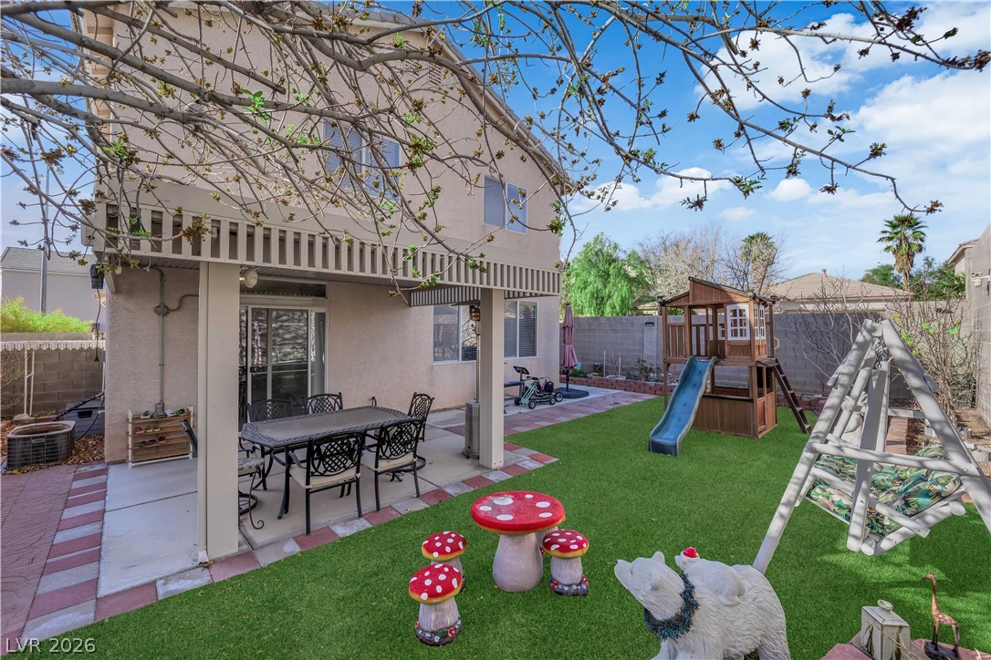 8170 West Festuca Way Las Vegas, NV 89113 - Photo 6 of 29 Fenced backyard with a patio area, a playground, a gazebo, and outdoor dining space