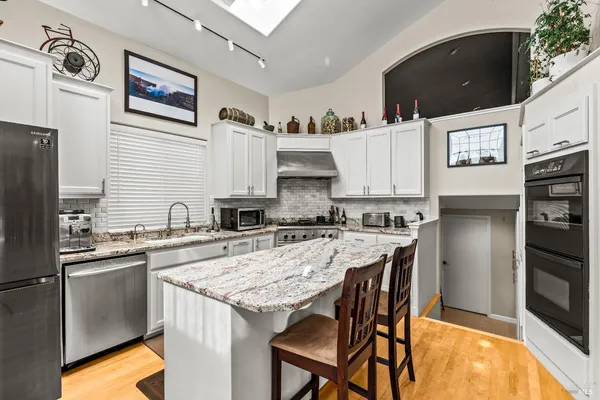 a kitchen with a sink a stove a refrigerator and cabinets