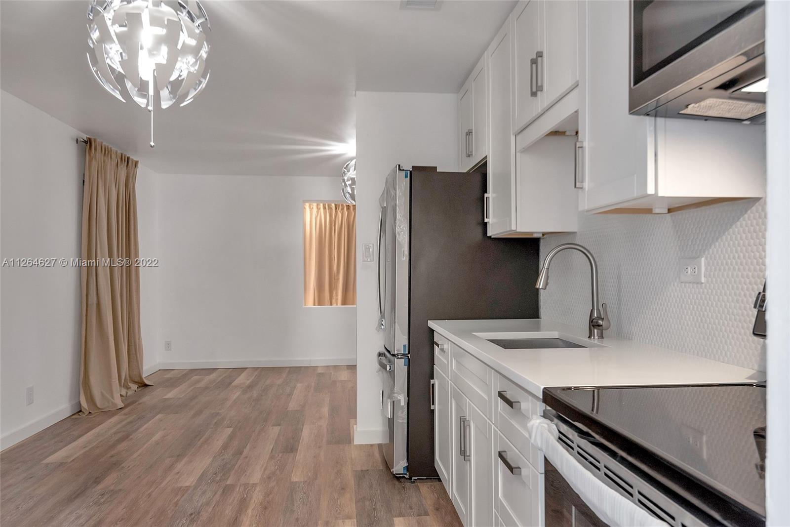 633 West 3rd Street Riviera Beach, FL 33404 - Photo 17 of 52 a kitchen with a sink stainless steel appliances a counter space and a window