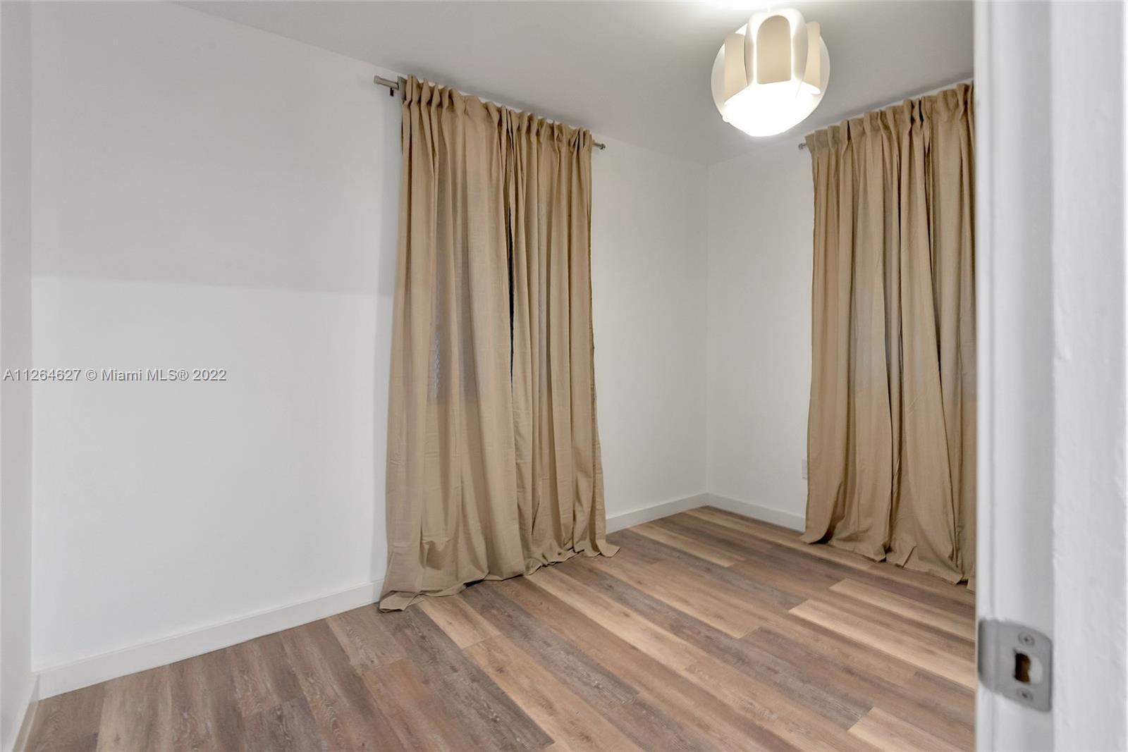 633 West 3rd Street Riviera Beach, FL 33404 - Photo 31 of 52 an empty room with wooden floor and a window