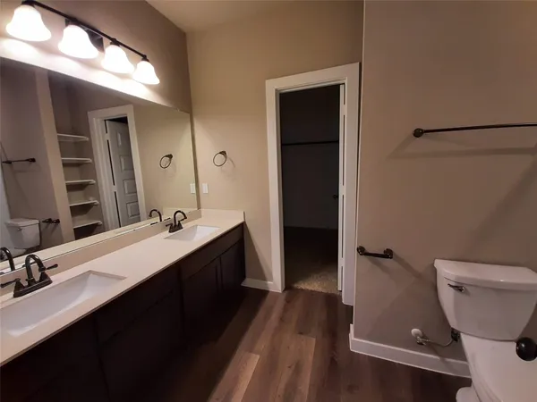 a bathroom with a double vanity sink toilet and shower