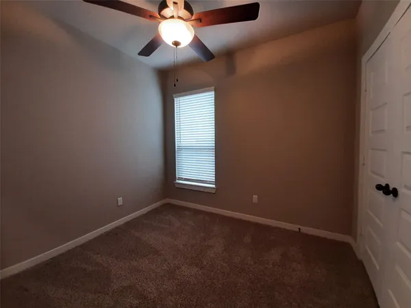 en empty room with windows and fan