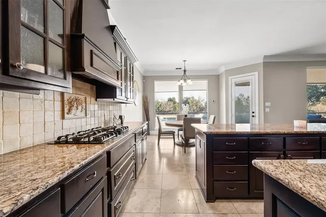 a kitchen with granite countertop a stove a sink and a microwave