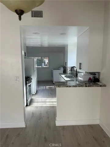 a kitchen with granite countertop a sink and a refrigerator
