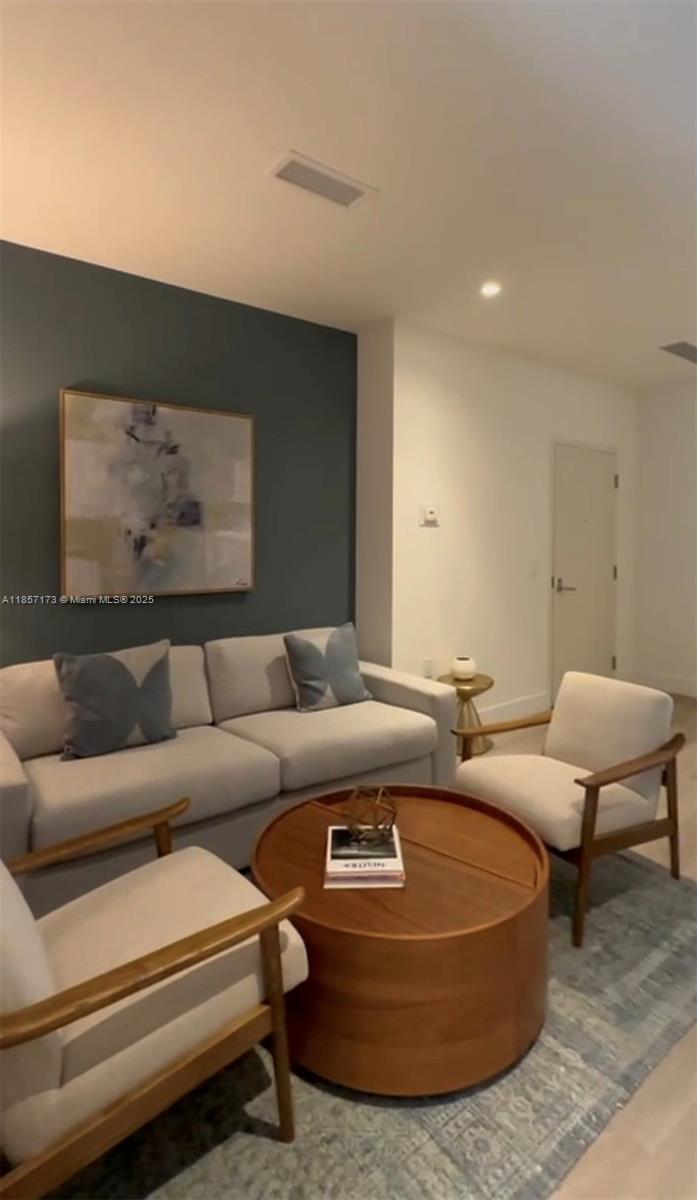 a living room with furniture a rug and a painting on the wall