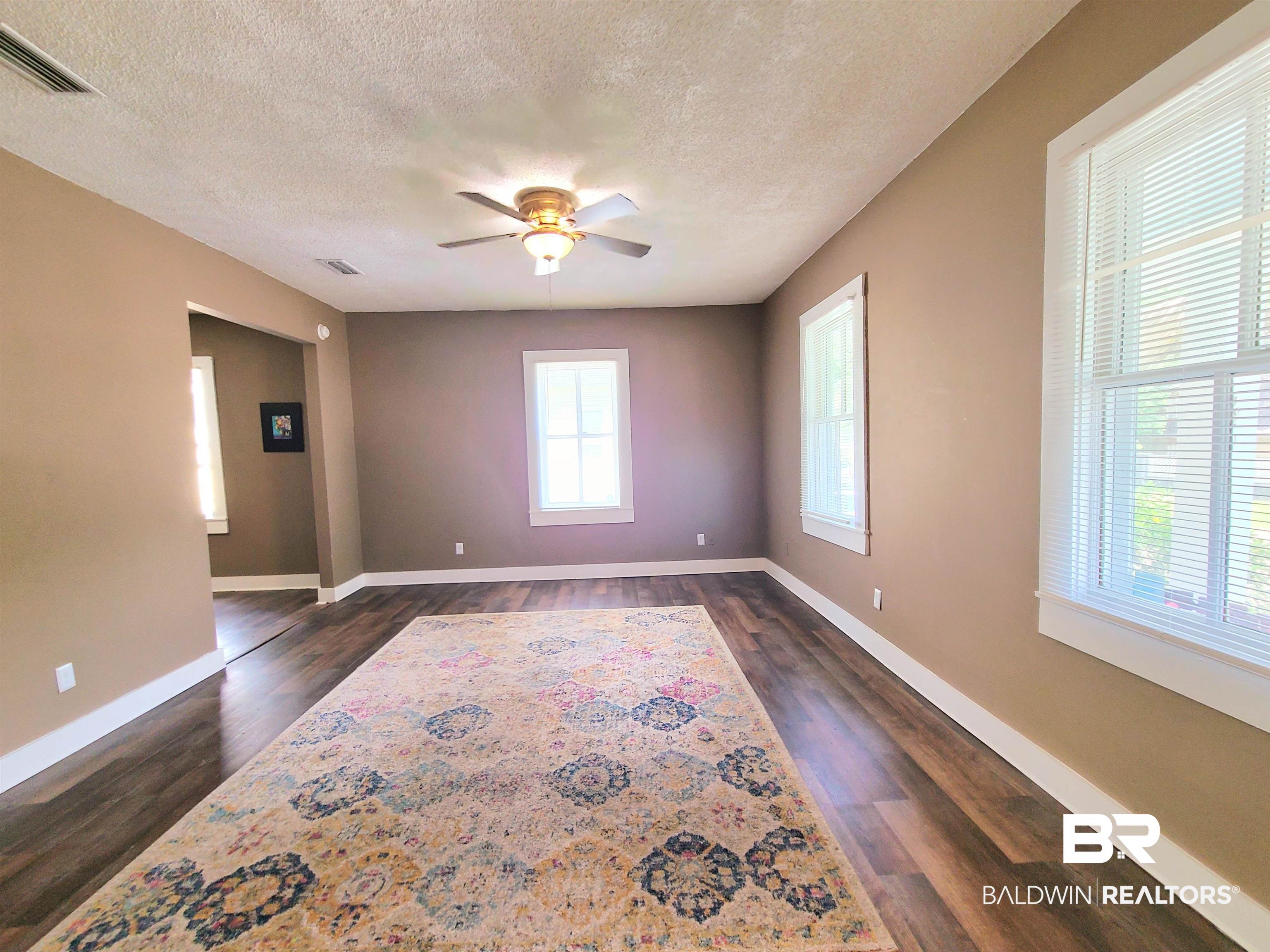 112 Espejo Street Mobile, AL 36604 - Photo 15 of 20 Unfurnished room featuring dark wood finished floors, visible vents, ceiling fan, and baseboards