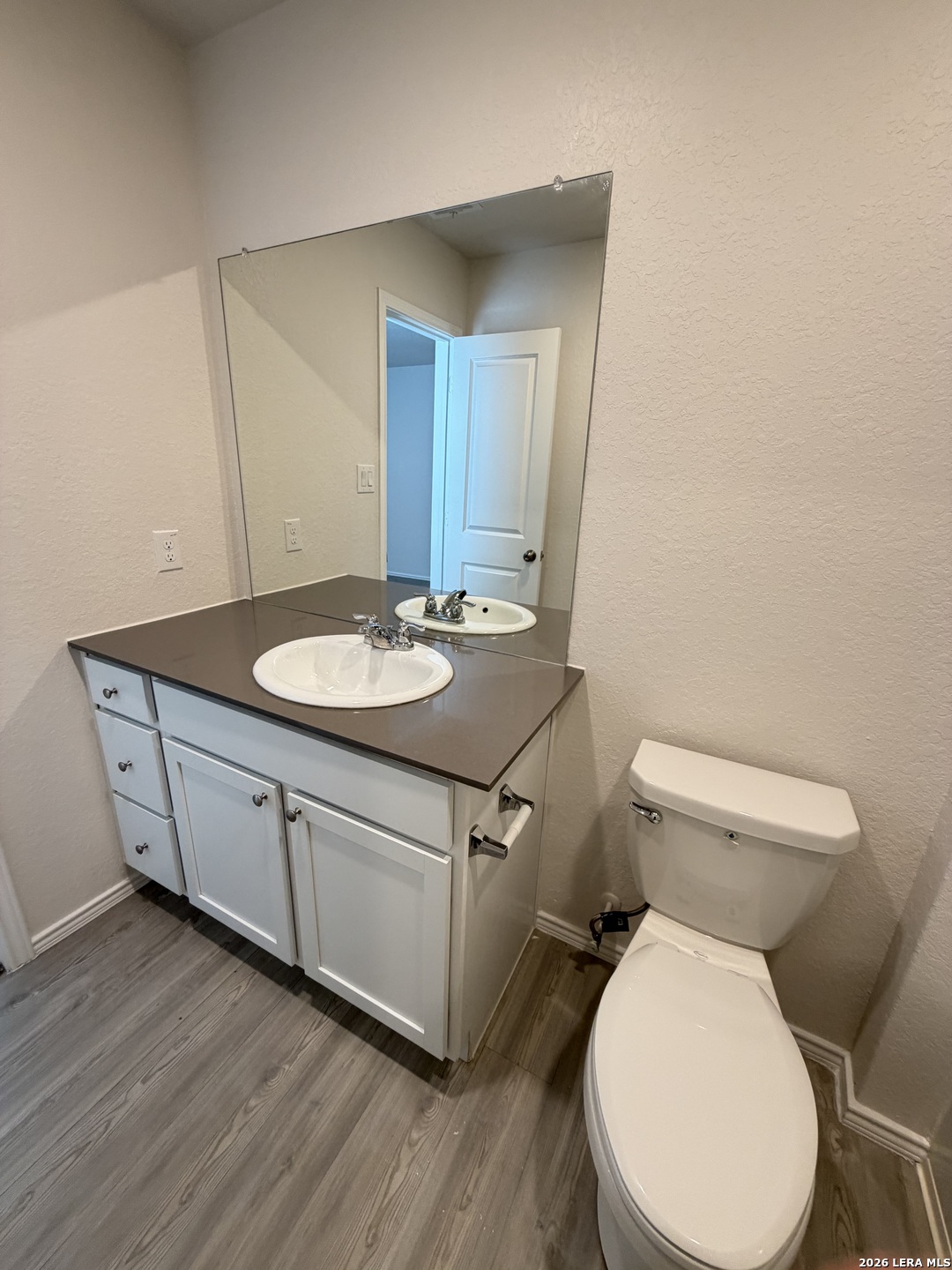 12914 Chinali St. Hedwig, TX 78152 - Photo 23 of 27 a bathroom with a granite countertop toilet sink and mirror