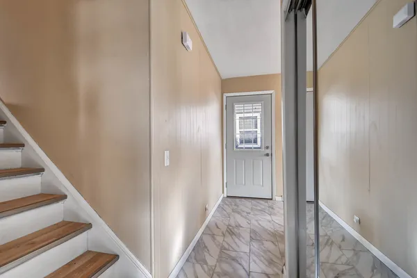 a view of a hallway with wooden floor and entryway
