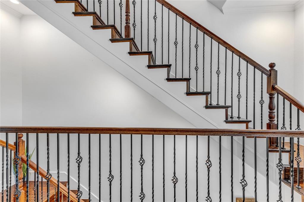 5744 Robbie Road Plano, TX 75024 - Photo 20 of 32 Architectural staircase featuring dark wood-finish treads and railings