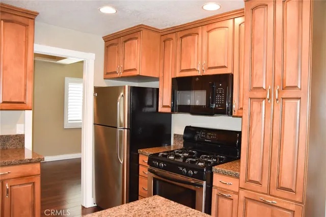 a kitchen with granite countertop a stove and a refrigerator