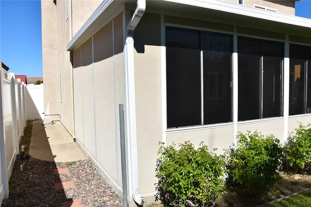 a backyard of a house with plants and large tree