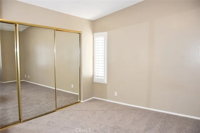 an empty room with a bathroom and mirror