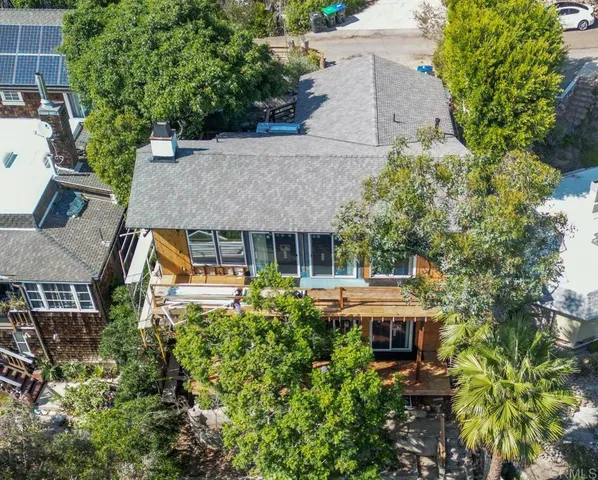 an aerial view of a house with a yard potted plants and large tree