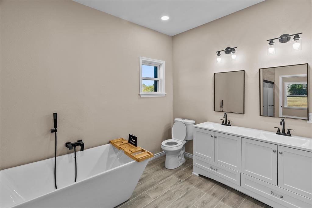 170 High Ridge Drive Azle, TX 76020 - Photo 13 of 36 a bathroom with a double vanity sink a toilet and a bathtub