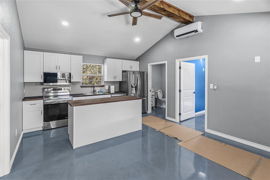 170 High Ridge Drive Azle, TX 76020 - Photo 25 of 36 a kitchen with stainless steel appliances kitchen island granite countertop a refrigerator a sink dishwasher a stove and white cabinets with wooden floor
