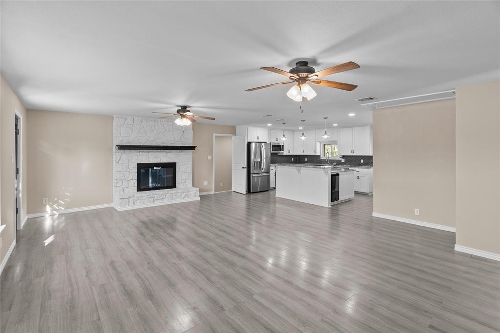 170 High Ridge Drive Azle, TX 76020 - Photo 4 of 36 a view of a kitchen with a ceiling fan hardwood floor and a fireplace