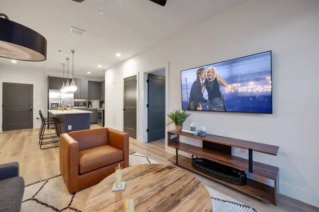 a living room with furniture a kitchen view and a fireplace