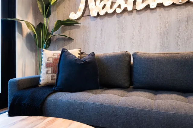 a bedroom with a bed lamp and a potted plant