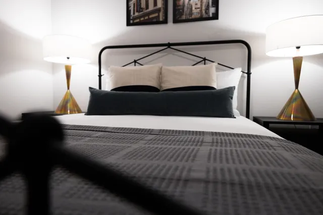 a bedroom with a bed and a black mirror