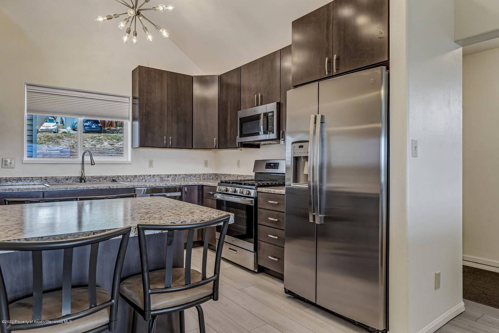 426 Lind Avenue Rifle, CO 81650 - Photo 3 of 20 a kitchen with stainless steel appliances granite countertop a refrigerator a sink and a stove