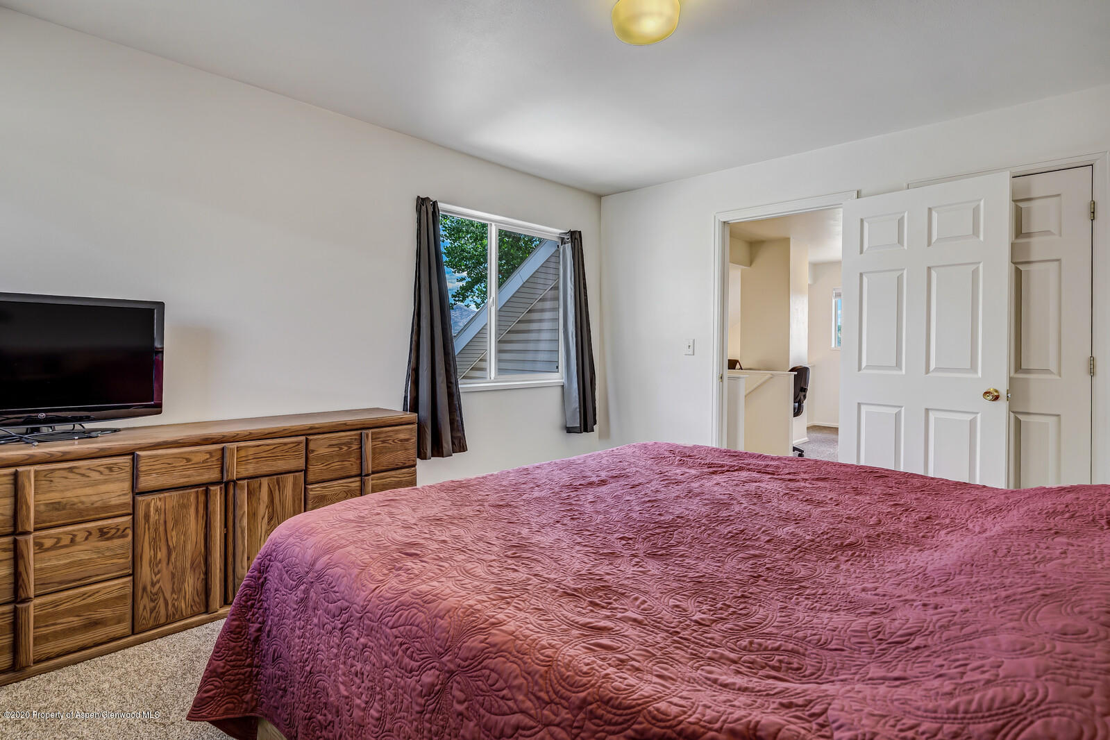 426 Lind Avenue Rifle, CO 81650 - Photo 10 of 20 a bedroom with a bed and a flat screen tv