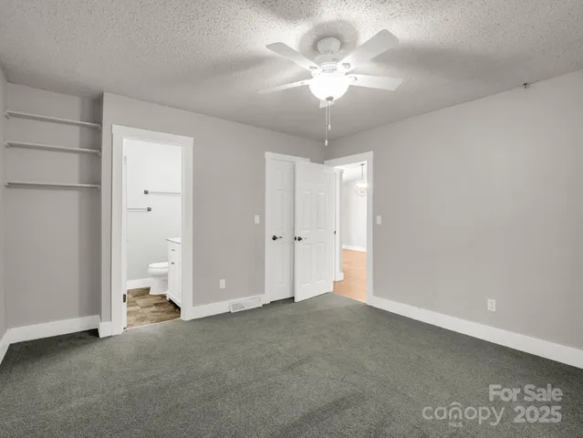 an empty room with a ceiling fan and bathroom