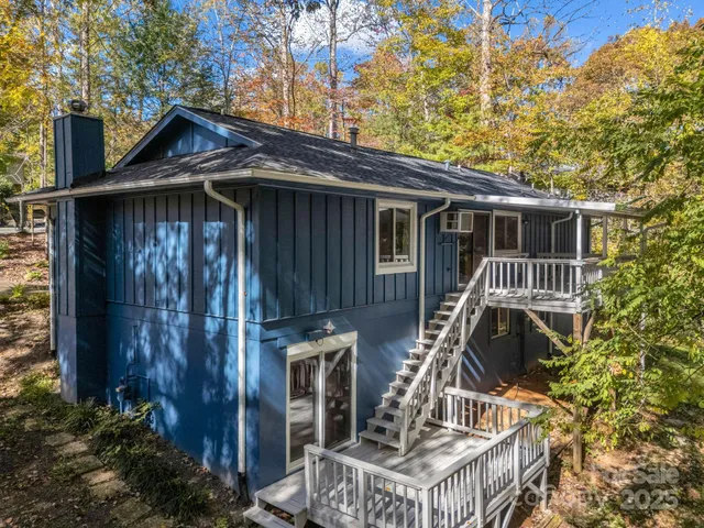 a view of wooden house with a small yard and wooden fence