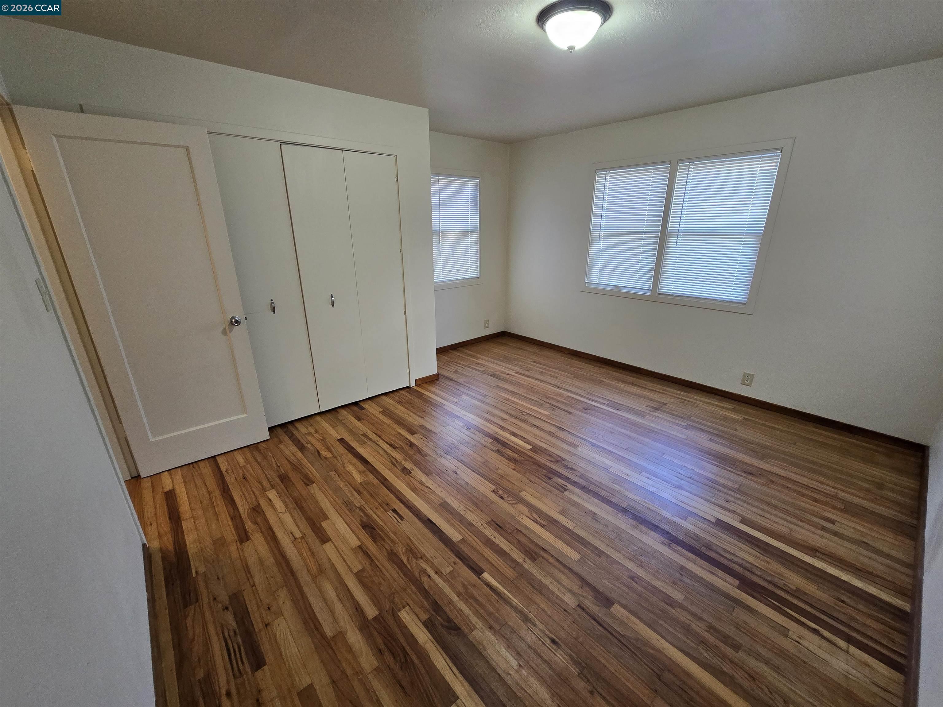 4455 Appian Way El Sobrante, CA 94803 - Photo 9 of 12 a view of an empty room with wooden floor and a window