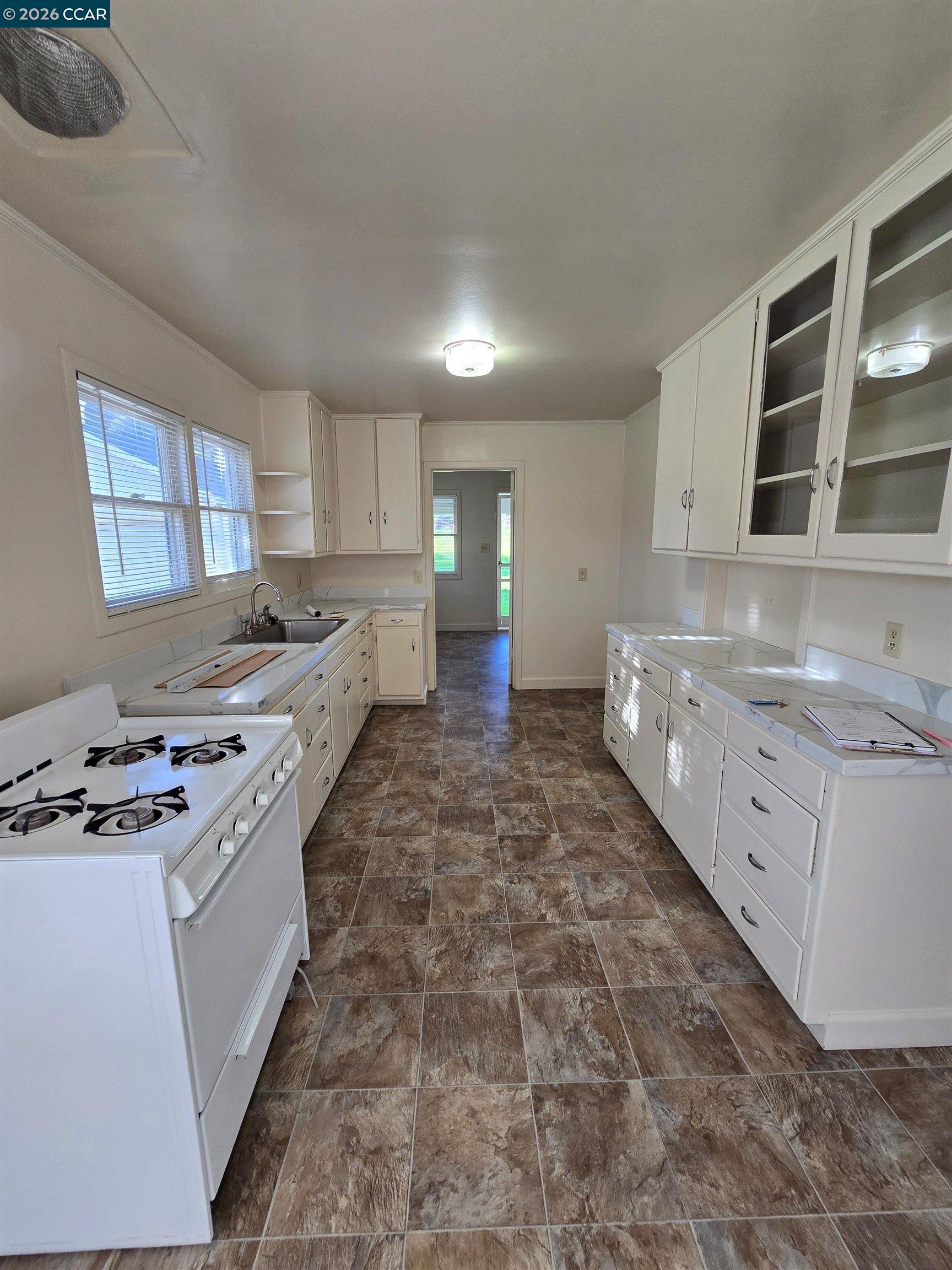 4455 Appian Way El Sobrante, CA 94803 - Photo 10 of 12 a kitchen with stainless steel appliances granite countertop a stove a sink and a refrigerator