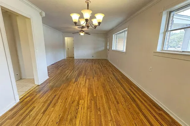a view of a room with wooden floor and chandelier
