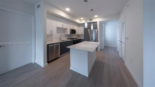 a kitchen with stainless steel appliances a stove refrigerator sink and microwave