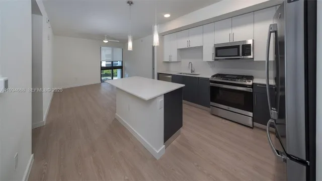 a kitchen with kitchen island a sink stainless steel appliances and cabinets